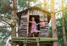 Drewniany domek zabaw w ogrodzie - alternatywa na drzewie albo na cokole